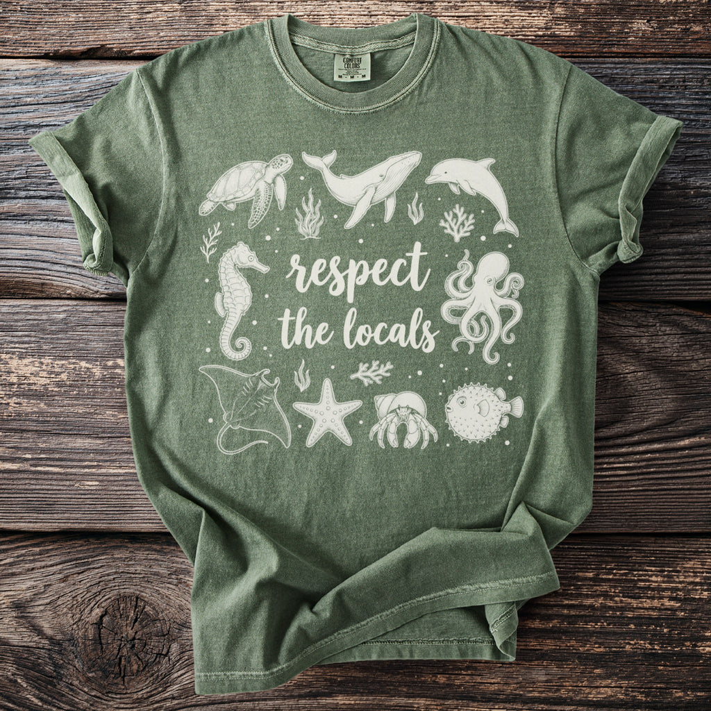 Green t-shirt with white ink art of sea creatures and text "respect the locals".