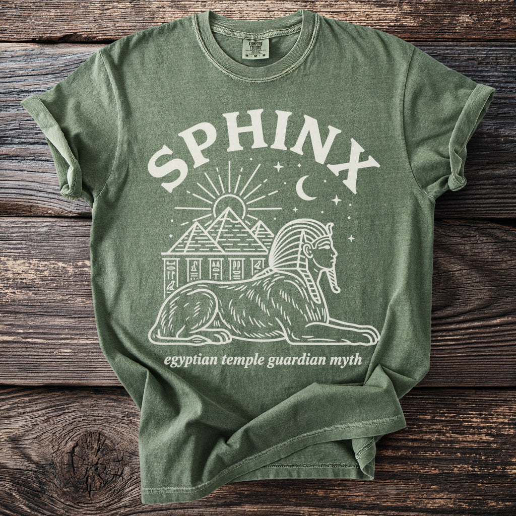 Olive green t-shirt with white sphinx, pyramids, sun, moon, and stars graphic.
