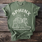 Olive green t-shirt with white sphinx, pyramids, sun, moon, and stars graphic.