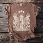Brown t-shirt with a cream graphic of a winged fairy, crescent moon, and celestial elements.