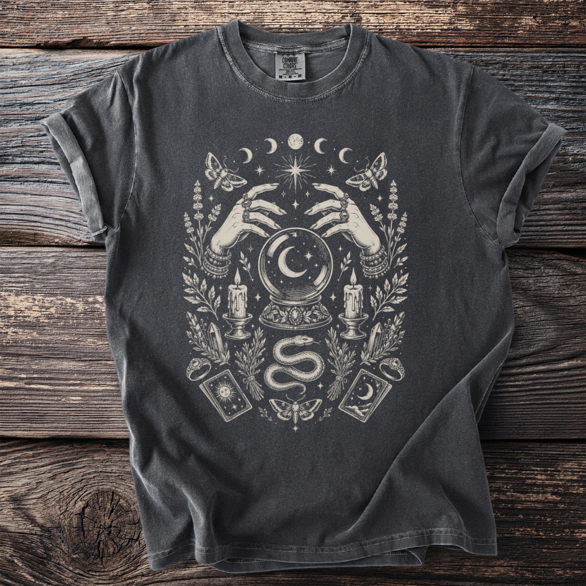Gray t-shirt with gothic occult graphic featuring hands, crystal ball, snake, and celestial elements.