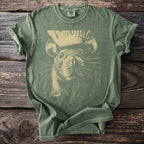 Olive green Comfort Colors t-shirt with a beige graphic of a chinchilla wearing a top hat.