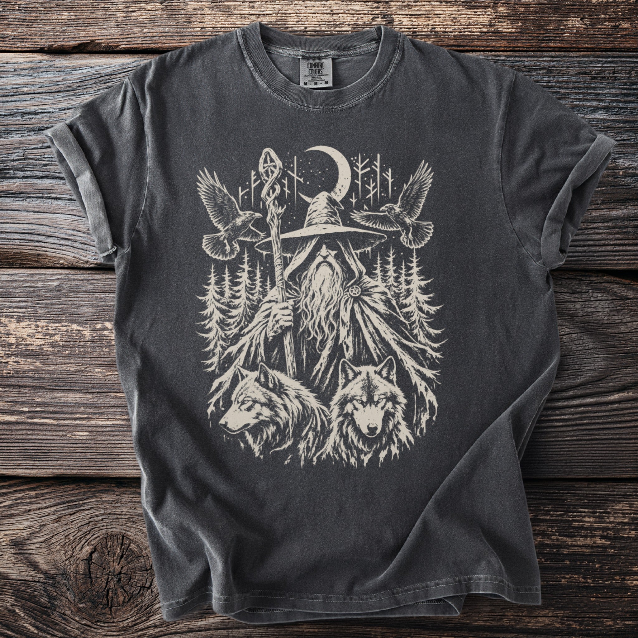 Dark grey t-shirt with a graphic of a wizard, two wolves, and two ravens in a forest.
