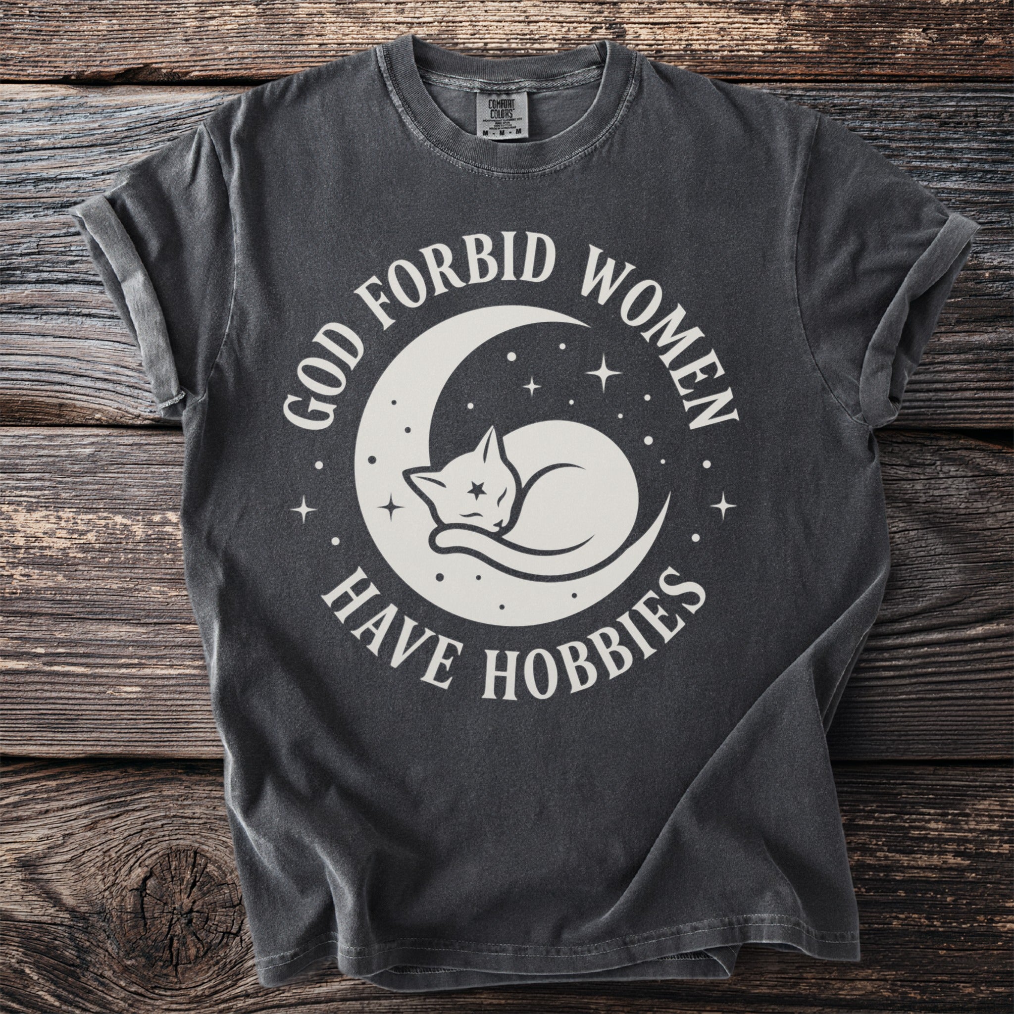 Dark t-shirt with white text and graphics of a cat on a moon.