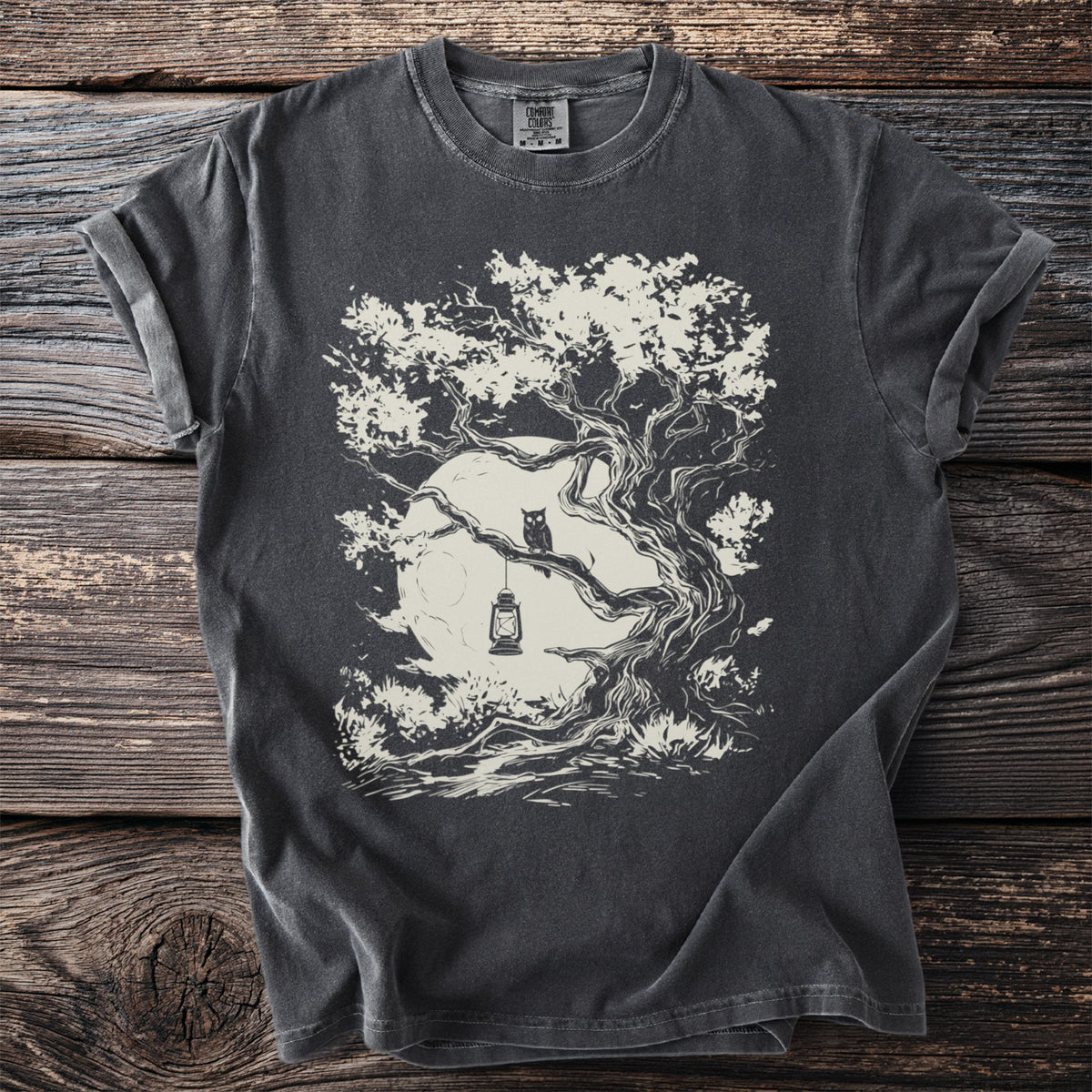 Dark t-shirt with an illustration of an owl on a branch with a lantern and moon.
