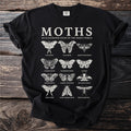 Black t-shirt featuring a "MOTHS AN ILLUSTRATED STUDY OF THE INSECT WORLD" graphic with multiple moth illustrations.