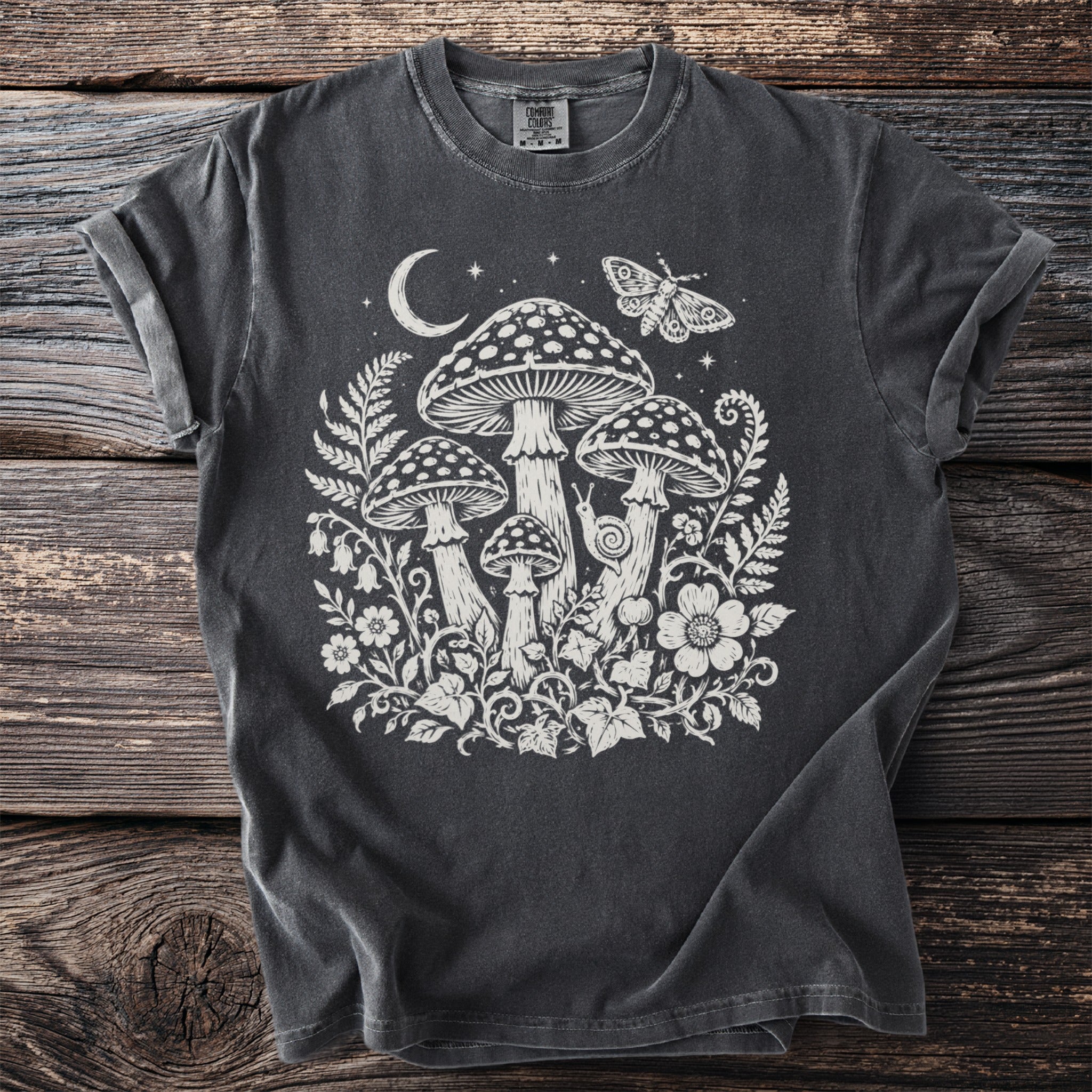 Dark t-shirt with white mushroom, moon, butterfly, and floral print.