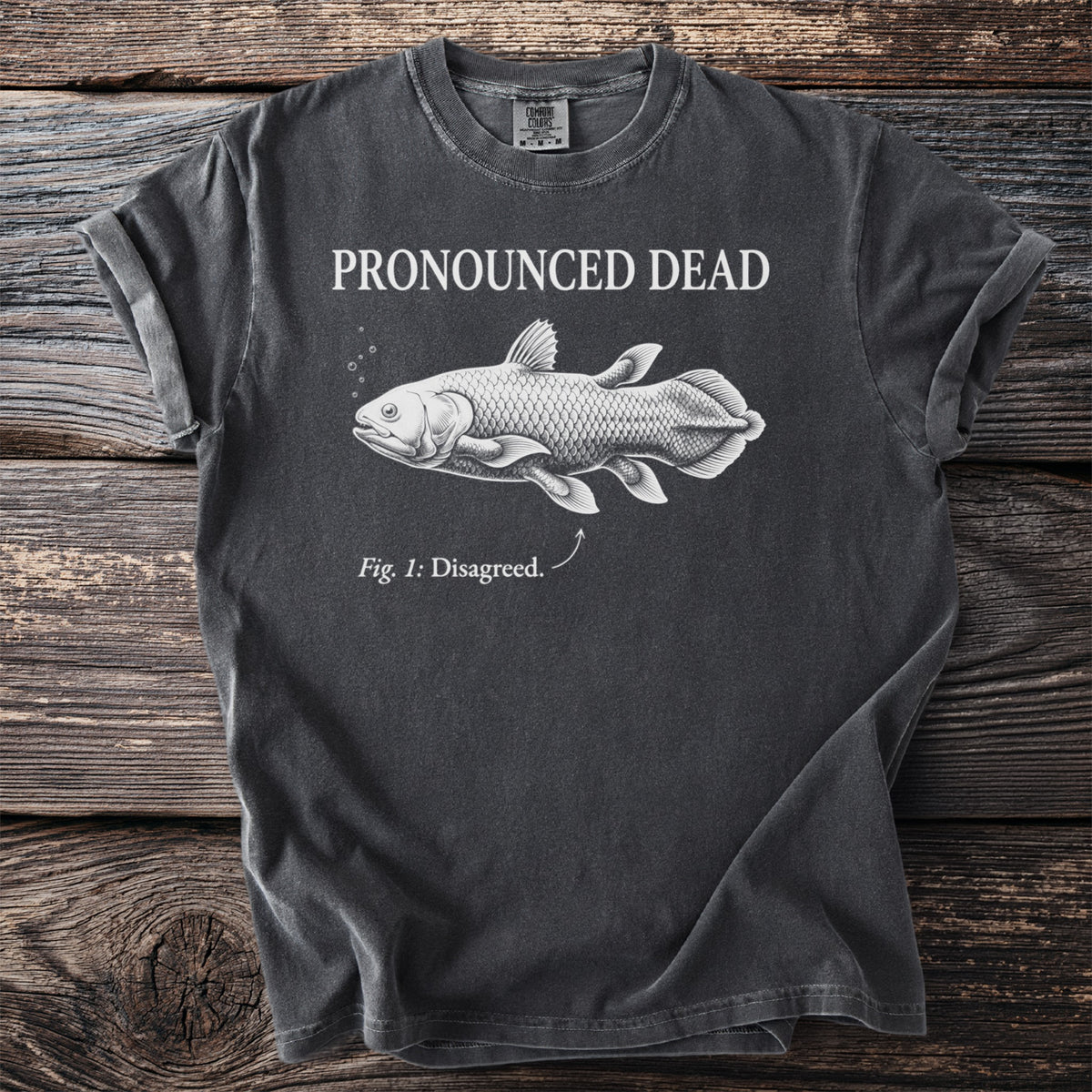 Charcoal t-shirt with a coelacanth illustration and text "Pronounced Dead. Fig. 1: Disagreed."