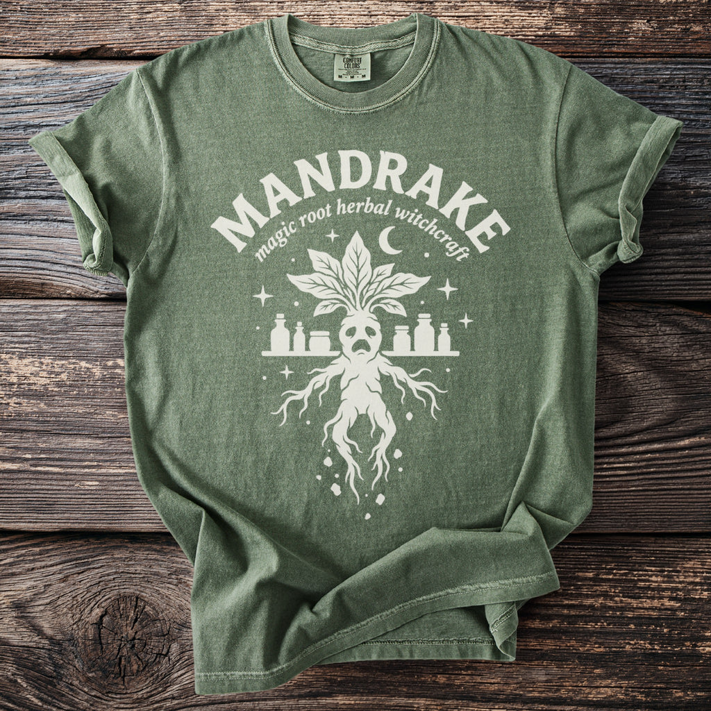 Green t-shirt with a white mandrake illustration and "MANDRAKE magic root herbal witchcraft" text.