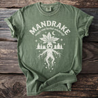 Green t-shirt with a white mandrake illustration and "MANDRAKE magic root herbal witchcraft" text.