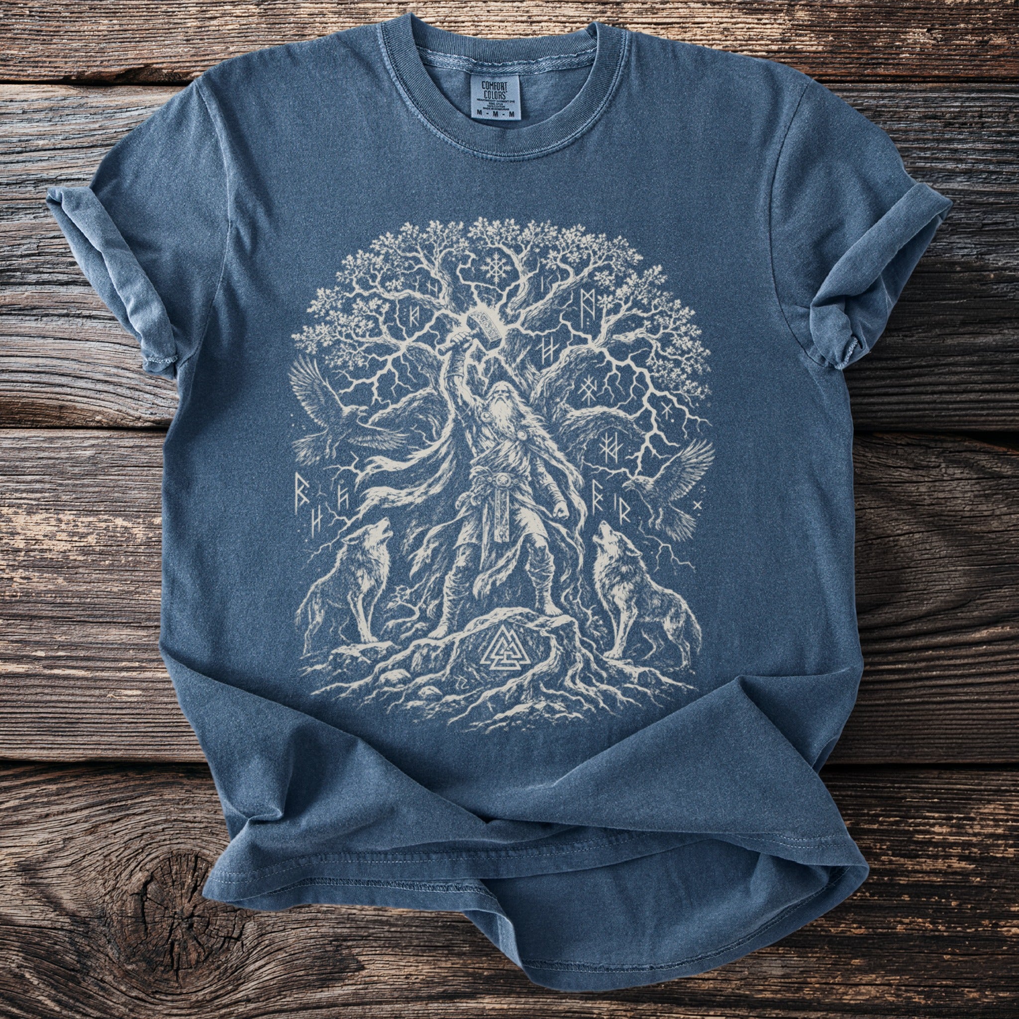 Blue t-shirt with white illustration of Norse mythology tree, Odin, wolves, and eagles.