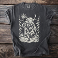 Pepper gray t-shirt with a cream folk-cut print: a bull-masked figure in a shaggy coat walks through a snowy village carrying a star on a pole.