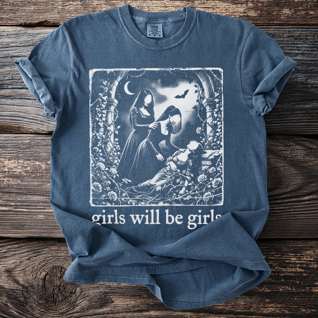 Blue t-shirt graphic with three women in dresses, roses, and a bat with text "girls will be girls."