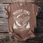 Brown t-shirt with white text "NIGHT OWL" above owl on branch with moon and trees.