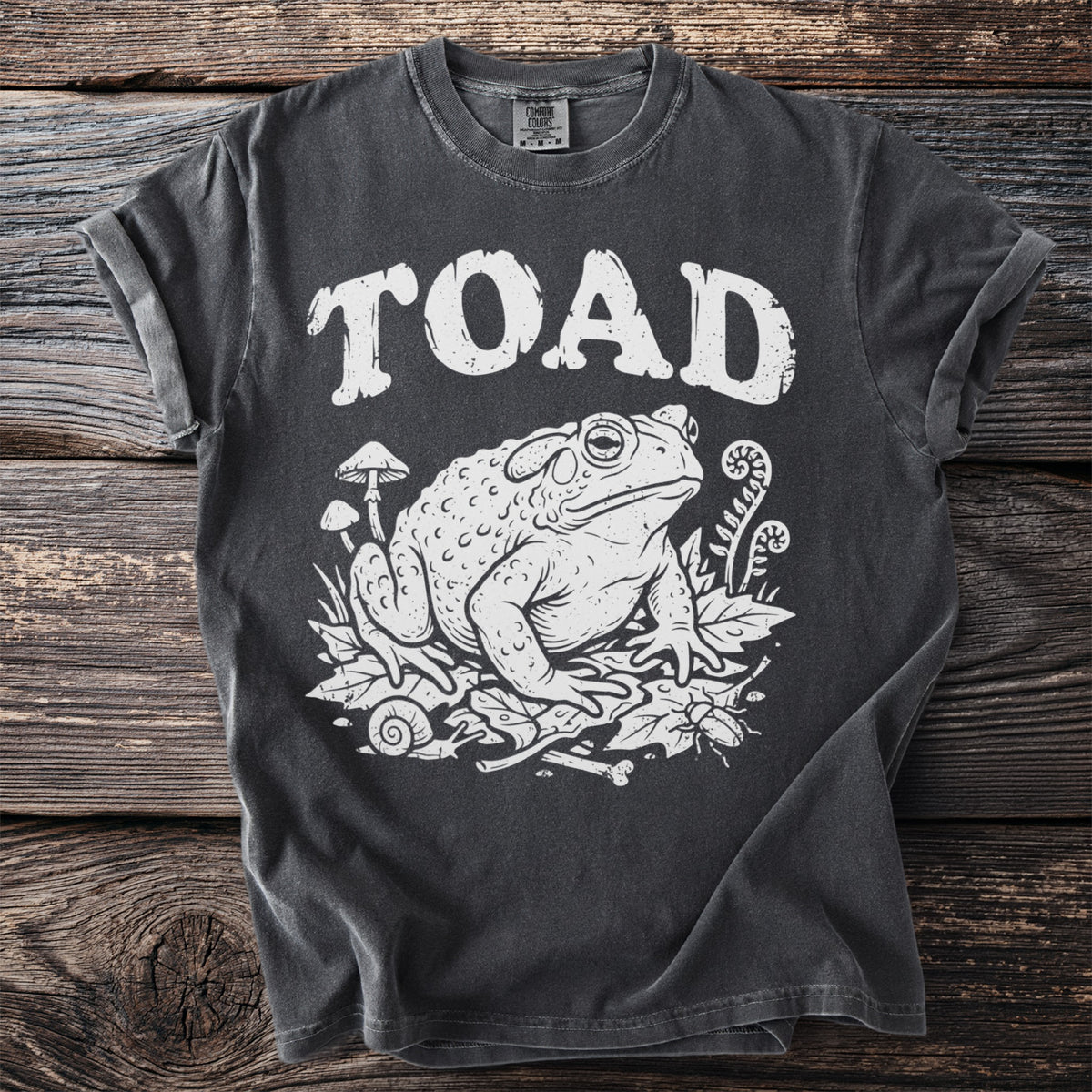 Dark grey t-shirt with distressed white print of "TOAD" above a toad, mushrooms, and insects.