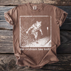 Brown t-shirt with a graphic of a werewolf and text "the evidence has teeth".