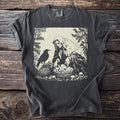 Dark gray t-shirt with a crone bending over a basket of mushrooms with a raven standing beside her among ferns.