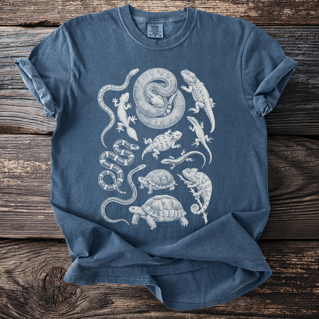 Blue t-shirt with white graphic of various reptiles including snakes and turtles.