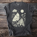 Dark gray t-shirt with a cream linocut design of two moths, flowers, and moon.