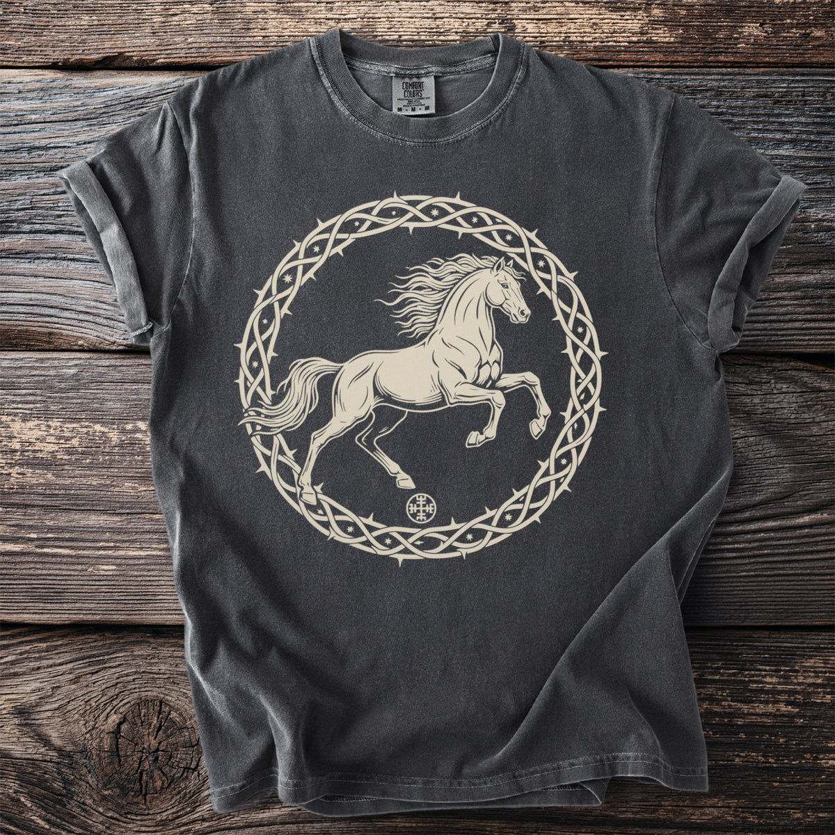 Dark t-shirt with a light-colored graphic of a horse inside a thorny circle.
