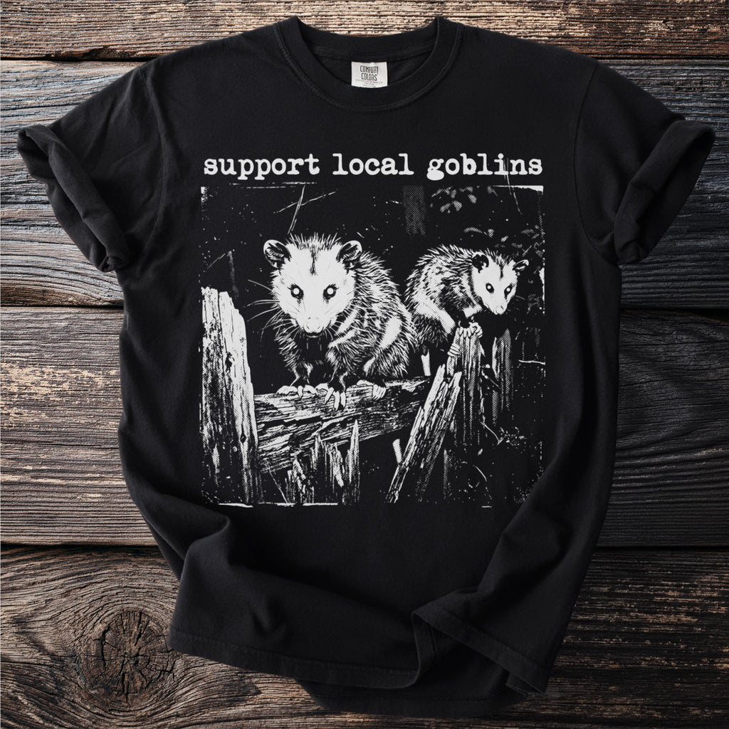 Black t-shirt with "Support Local Goblins" text and two possums on a fence.