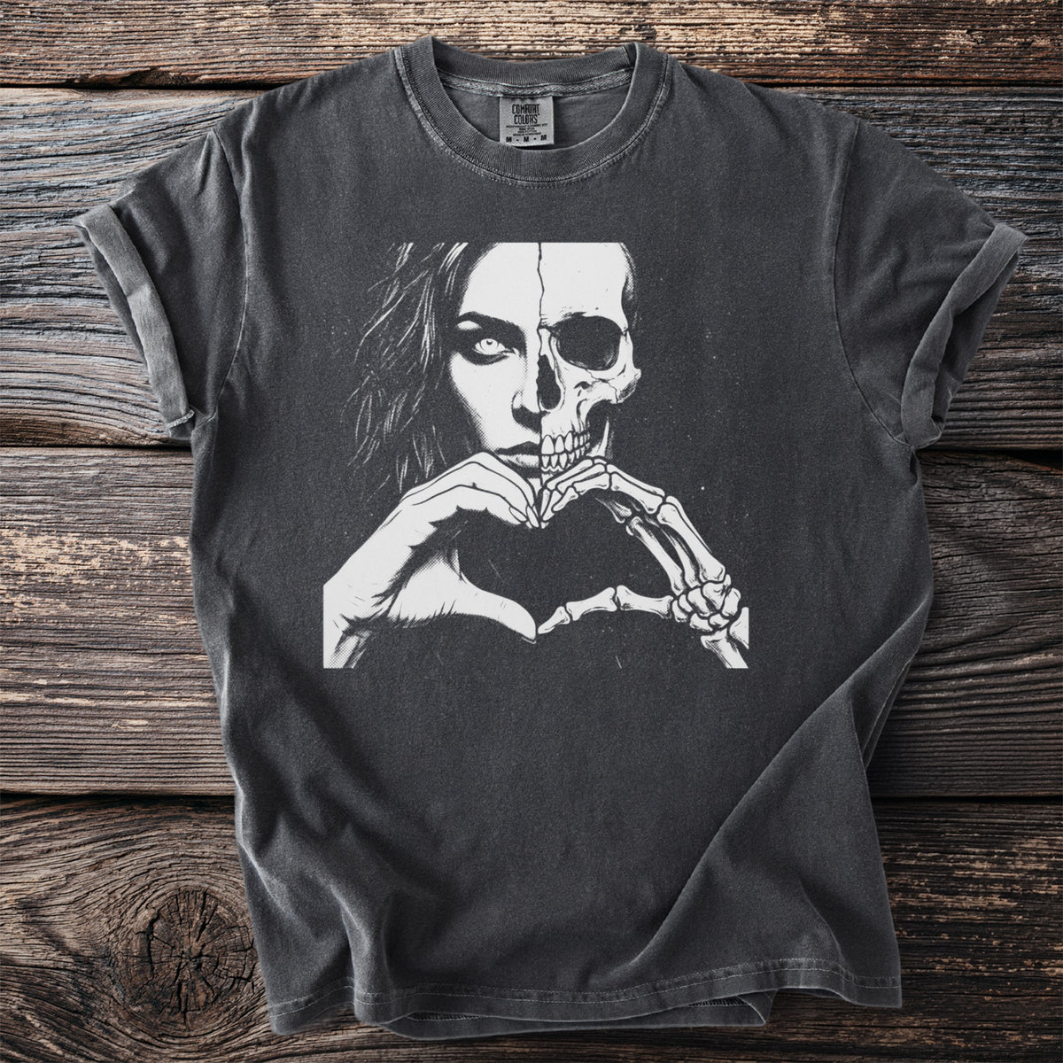 T-shirt with split face of woman and skull making a heart shape with hands.