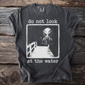 Dark grey t-shirt with tentacled creature and text "do not look at the water".