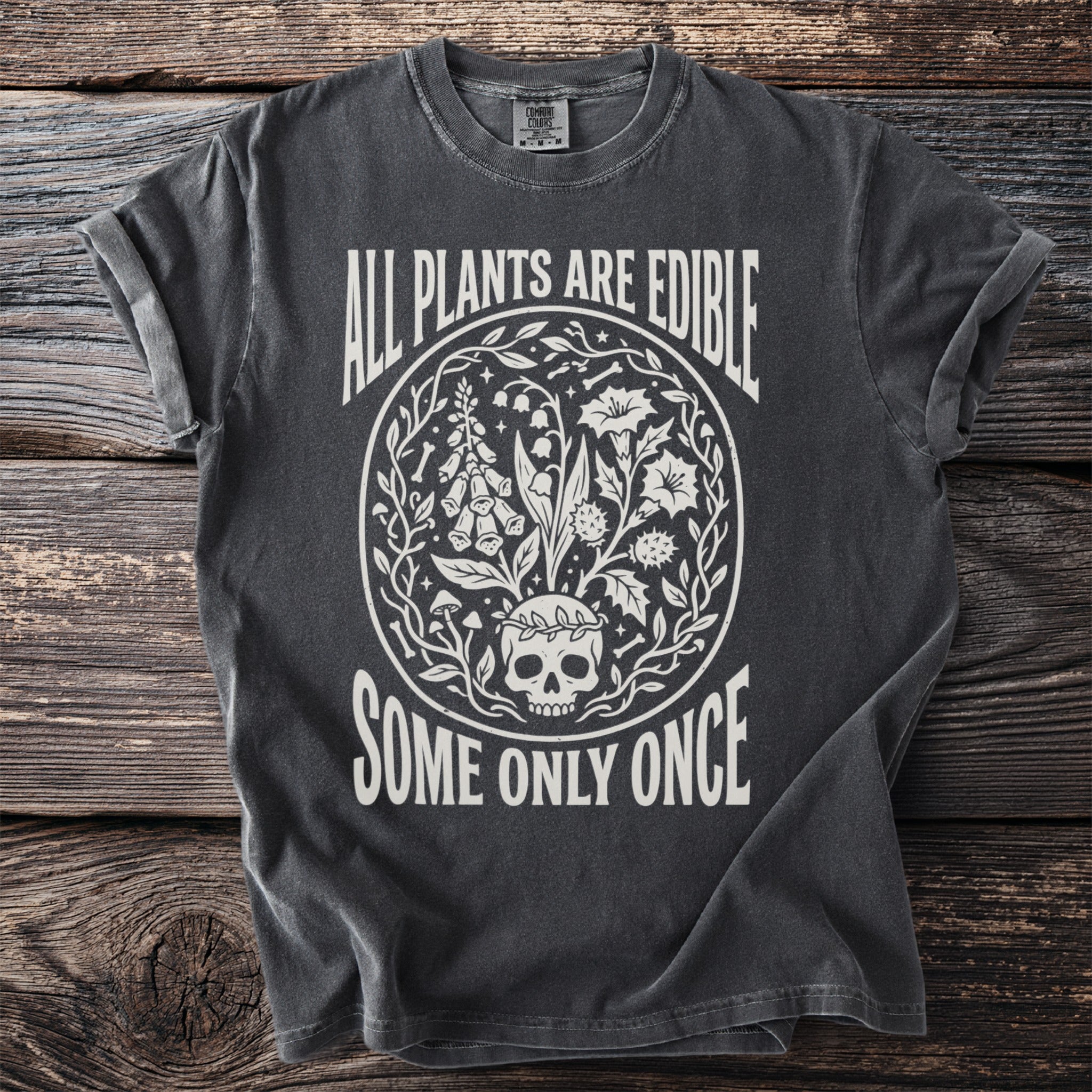 Dark t-shirt with white text "All Plants Are Edible Some Only Once" and skull and plant graphic.