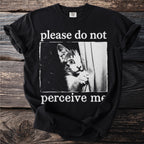 Black t-shirt with a vintage-style graphic of a kitten peeking and the text "please do not perceive me."