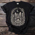 Black t-shirt with a tondo graphic of figures in robes dancing around a campfire under a moon.