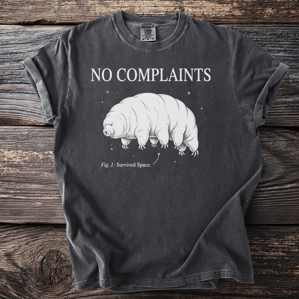 Dark grey t-shirt with "NO COMPLAINTS" and a tardigrade graphic labeled "Fig. 1: Survived Space."