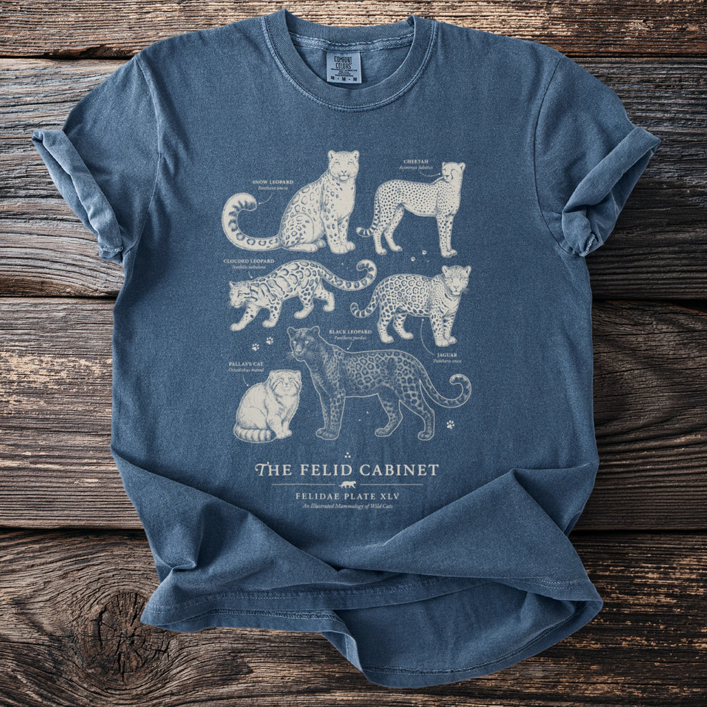 Blue t-shirt with illustrations of wild cats and text "The Felid Cabinet".