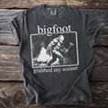 T-shirt with Bigfoot at a campfire grilling a hot dog and text "bigfoot grabbed my weiner".