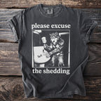 Dark grey t-shirt with a werewolf at a sink and the text "please excuse the shedding."
