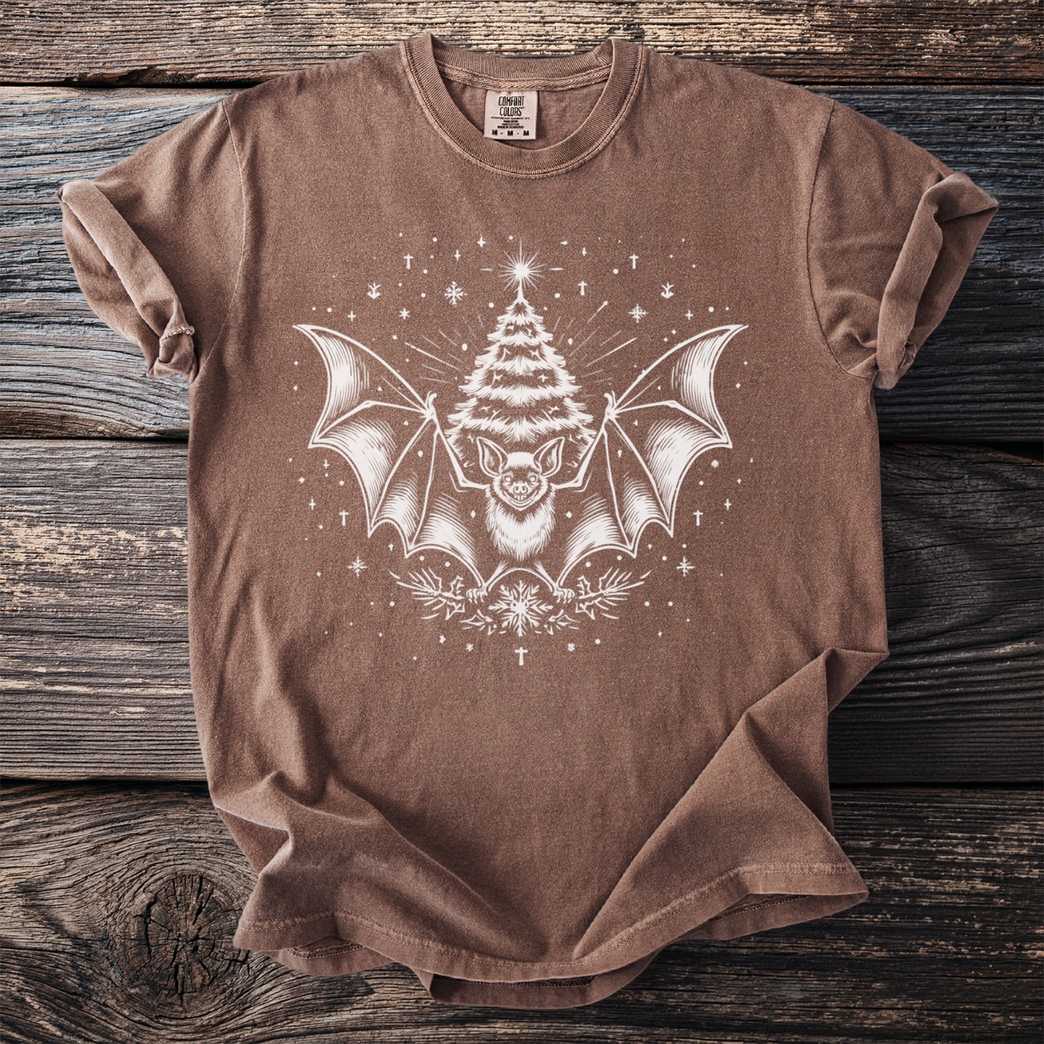 Brown t-shirt with a white graphic of a bat and a Christmas tree.