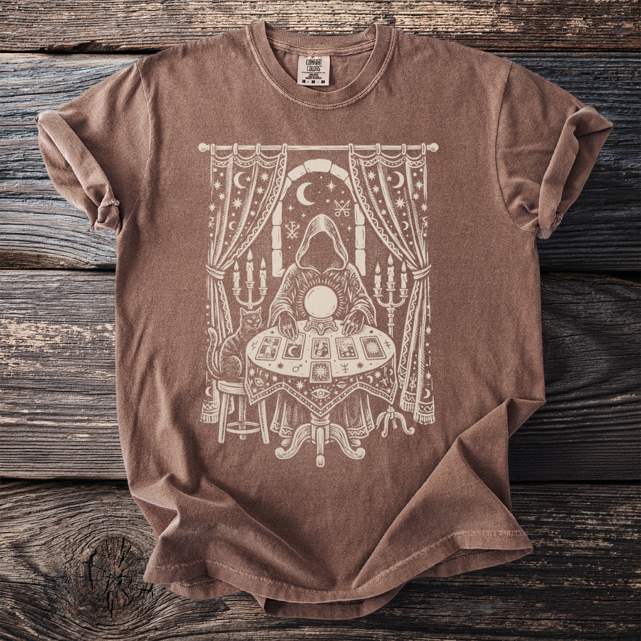 Brown t-shirt with a mystical seer, crystal ball, and tarot cards design.