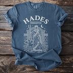 Blue t-shirt with white graphic of Hades, Cerberus, snake, and Greek architecture.