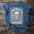 Blue t-shirt with a graphic of a skull, bones, and plants with text "All Plants are Edible Some Only Once".