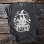 Dark gray t-shirt with white witchy floral design and potion bottles.