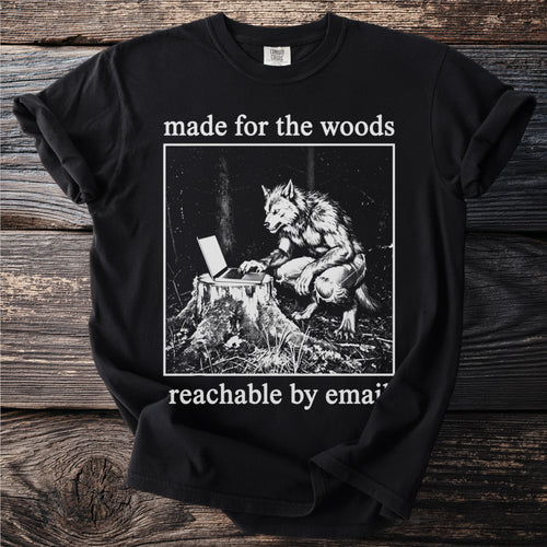 Black t-shirt with werewolf using a laptop on a tree stump, "made for the woods" and "reachable by email".