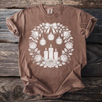 Brown t-shirt with a floral wreath design featuring candles, ornaments, and roses.