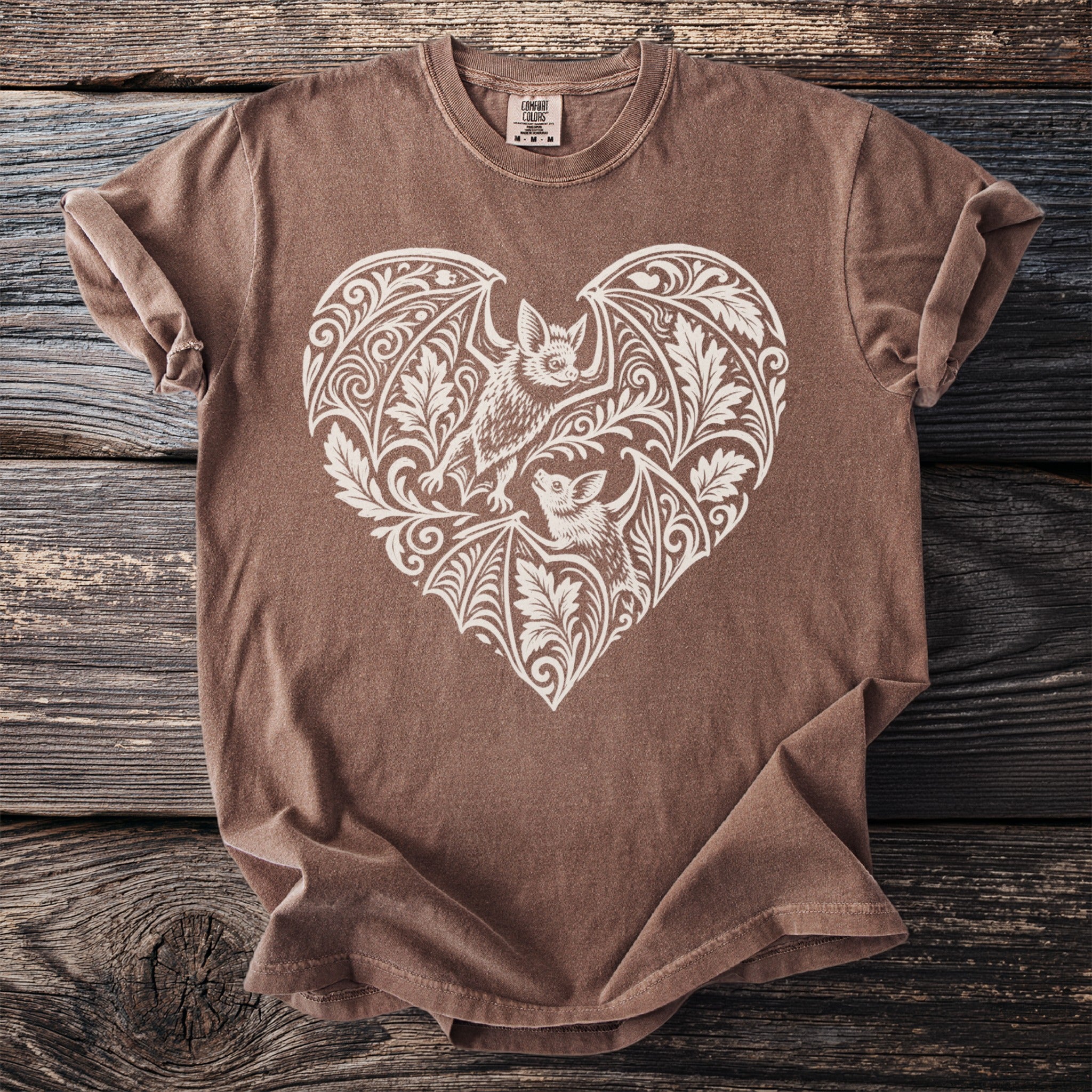 Brown t-shirt with a white heart-shaped bat and floral design.
