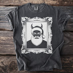 Dark t-shirt with distressed graphic of a devilish Santa Claus in an ornate frame.