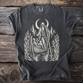 T-shirt with a graphic of a hooded figure poling a boat with passengers under a crescent moon.