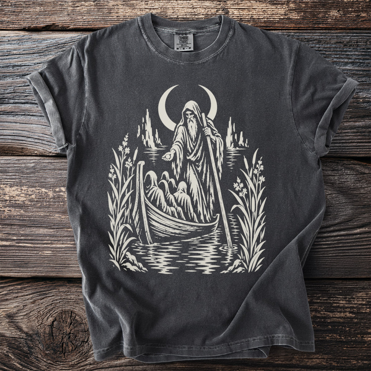 T-shirt with a graphic of a hooded figure poling a boat with passengers under a crescent moon.