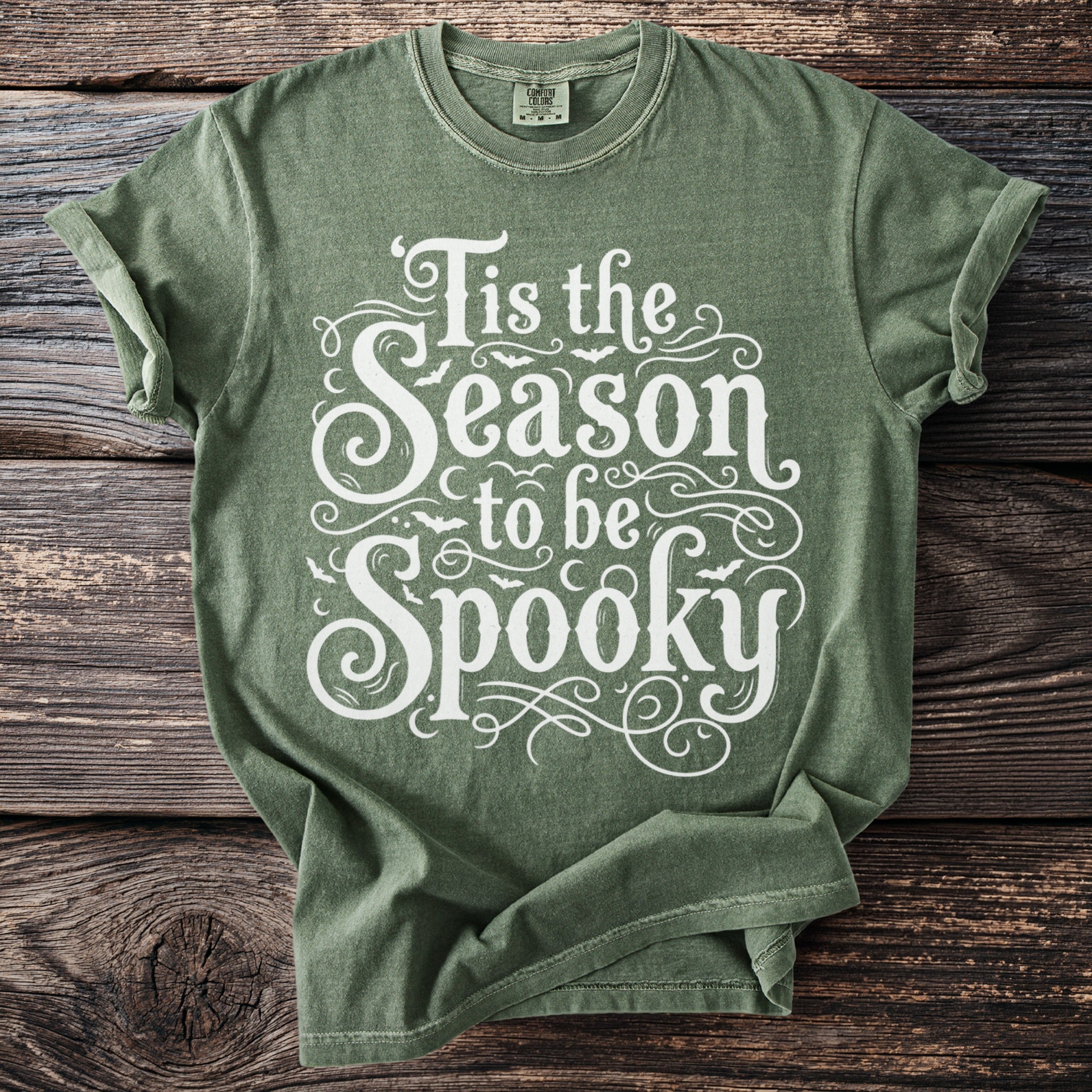 Green t-shirt with white text "Tis the Season to be Spooky" and bats.