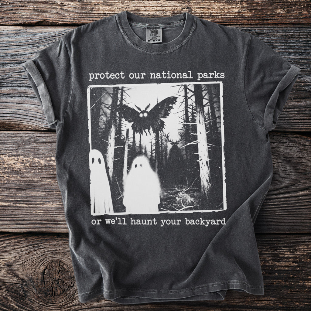 Dark t-shirt with "protect our national parks or we'll haunt your backyard" text and graphic.