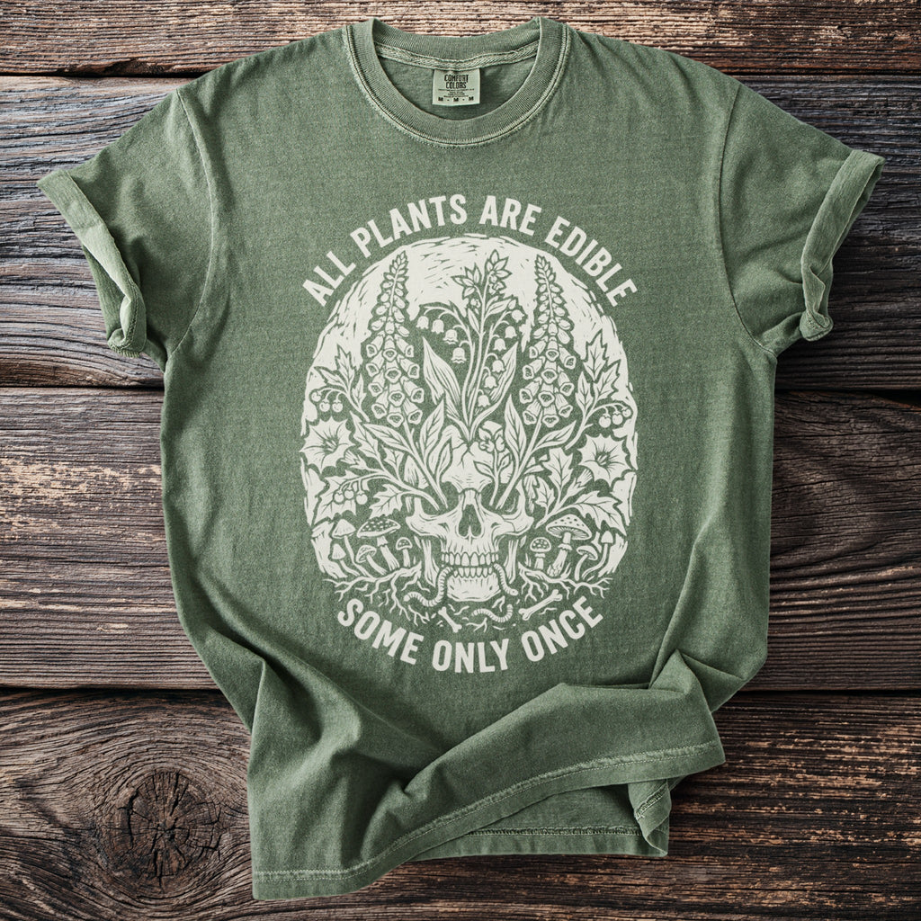 Green t-shirt with skull and botanical graphic, text "ALL PLANTS ARE EDIBLE SOME ONLY ONCE".