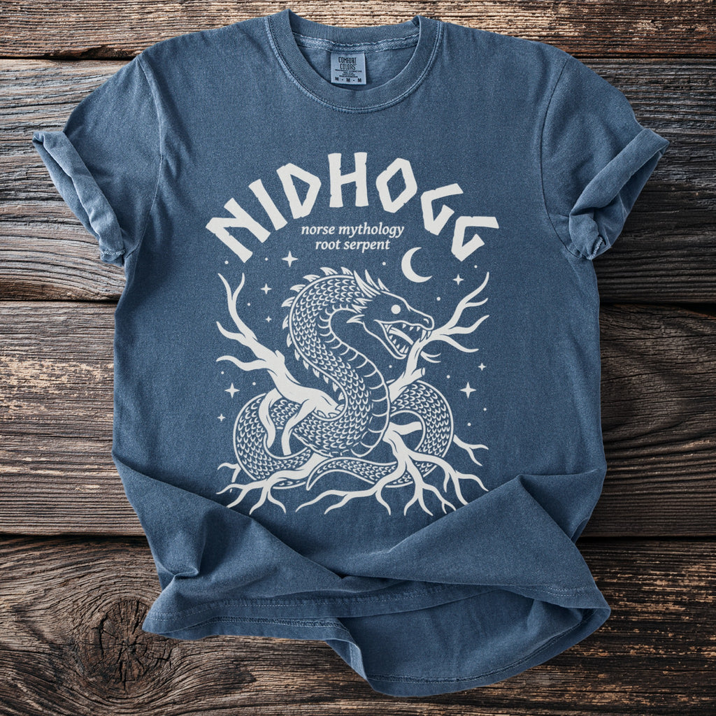 Blue t-shirt with white graphic of a dragon, roots, and stars. Texto reads "Nidhogg Norse mythology root serpent".