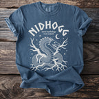 Blue t-shirt with white graphic of a dragon, roots, and stars. Texto reads "Nidhogg Norse mythology root serpent".